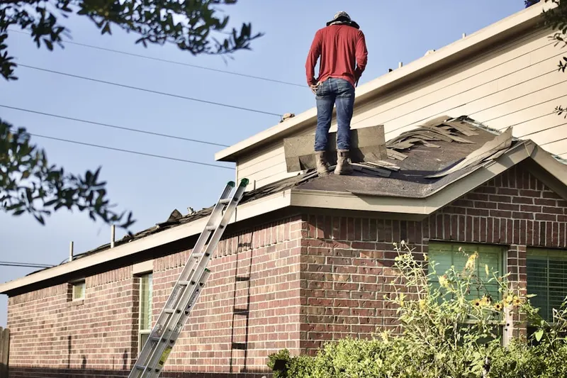 Professional roofer working on a residential roof in Caruthers